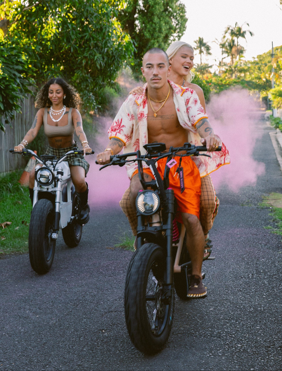 Three People riding two e_bikes down a coastal laneway in Shellharbour Kiama area. Happy and enjoying the freedom a e-bike can give.